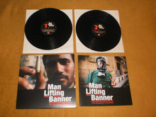 Man Lifting Banner: The Revolution Continues 2x12"